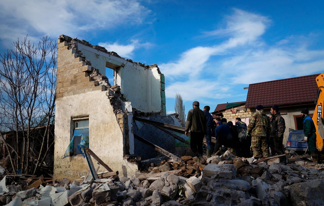 Добровольцы сносят остатки стен дома, разрушенного наводнением, в поселке Мамедкала в Дербентском районе