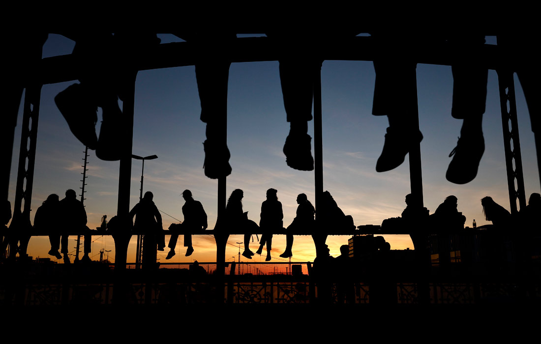 Жители Мюнхена на мосту Хакербрюкке во время заката