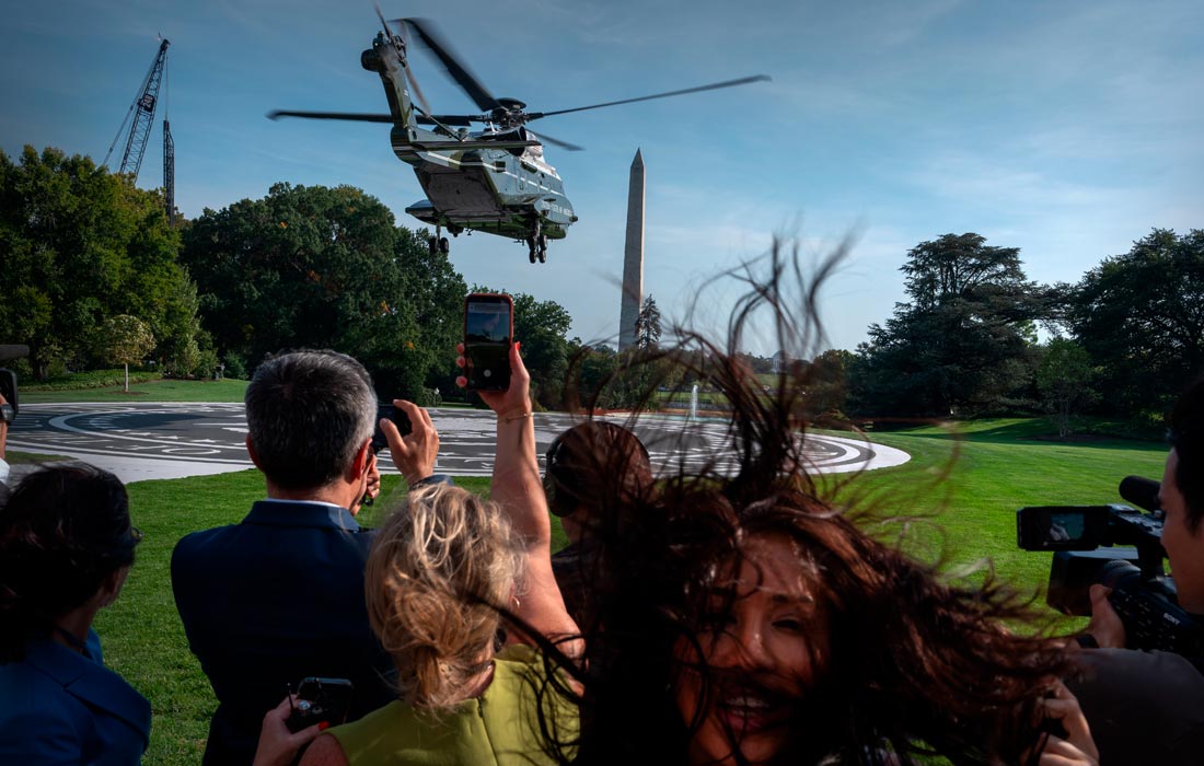 Журналисты наблюдают за взлетом вертолета Marine One с президентом Дональдом Трампом на борту с Южной лужайки Белого дома в Вашингтоне