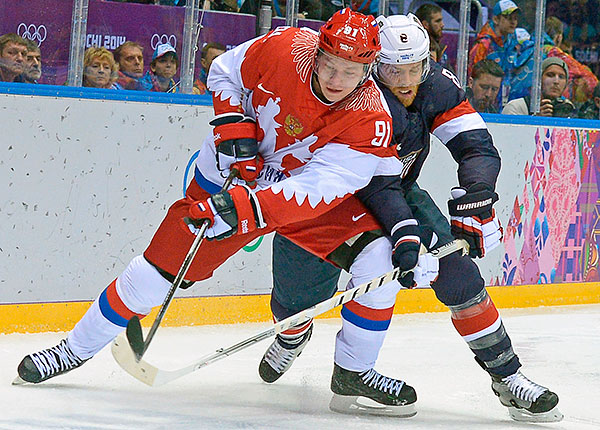 Слева направо: Владимир Тарасенко (Россия) и Джо Павелски (США) в матче группового этапа между сборными командами США и России на соревнованиях по хоккею среди мужчин на XXII зимних Олимпийских играх в Сочи.