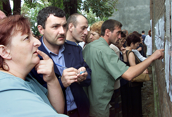 Родные и близкие у стены больницы, на которой вывешены списки пострадавших в результате теракта.