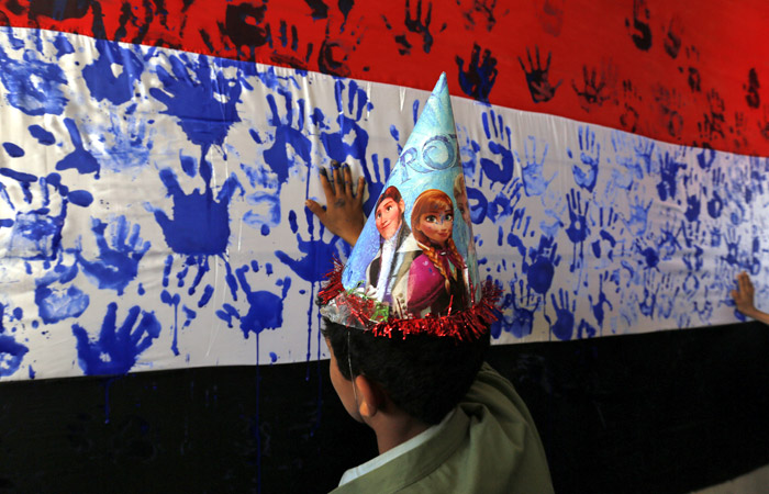 В столице Йемена ребенок принимает участие в протесте против молчания мирового сообщества перед агрессиями Саудовской Аравии