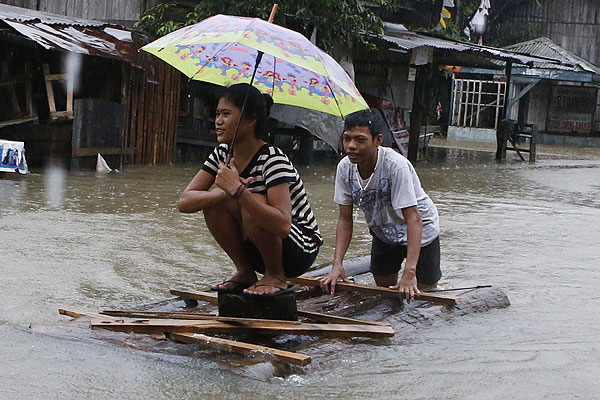 Жители деревни Бутуан прокладывают себе водный путь к убежищу.